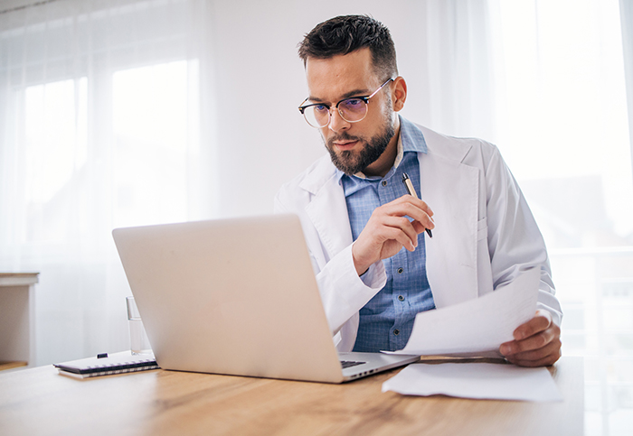 commonly asked questions doctor with paper and laptop