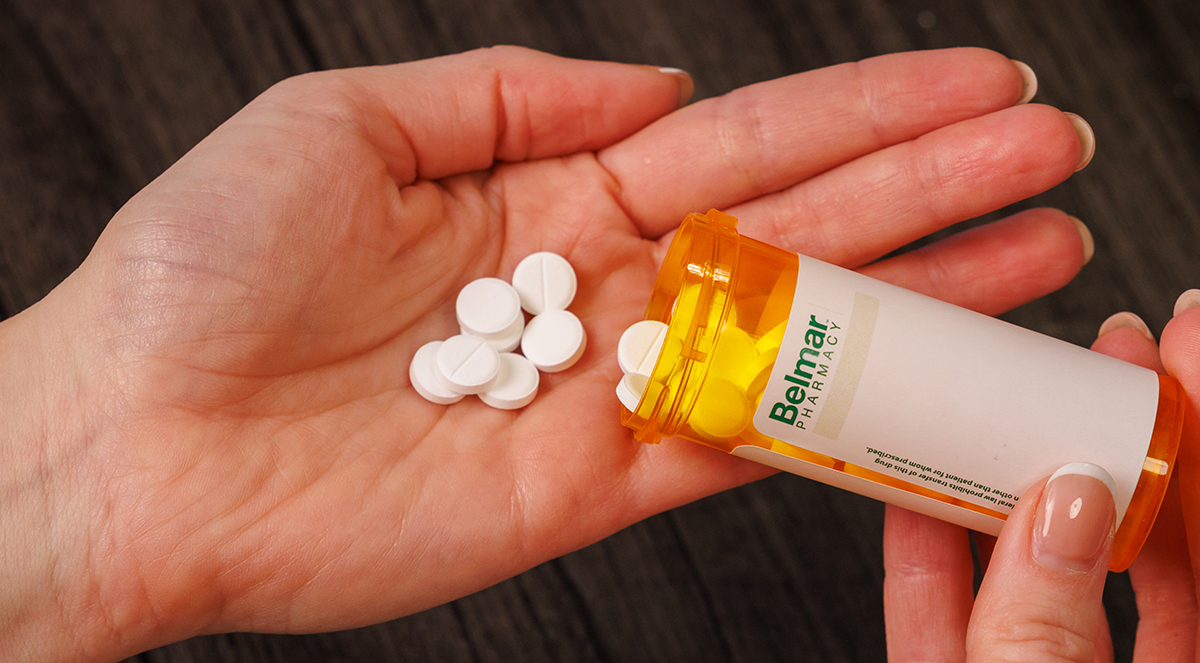 compounded medication bottle tipping pills into a hand