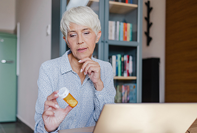 medication package inserts image of a woman reading a prescription bottle